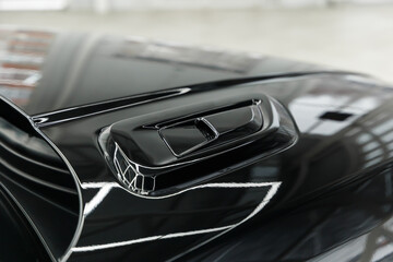 Black air intake on the hood - close-up. The aerodynamic grille closes the air intake system....