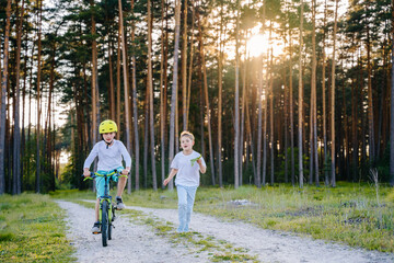 Summer vacation for inquisitive kids in forest. Two boys in green forest at summer daytime...