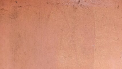 Cracks on the old orange wall and peeling paint.