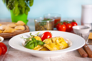 Homemade traditional italian ravioli pasta with basil and tomato cherry vegetables on the table