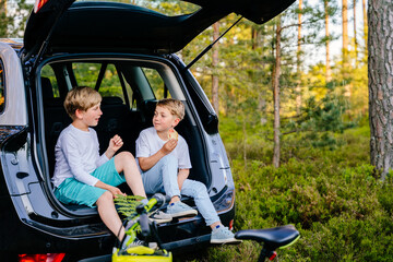 Summer vacation for inquisitive kids in forest. Snack in the forest. Fun friendly children sits at...