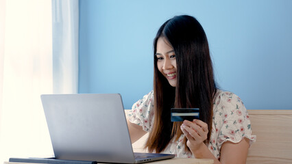 Fototapeta premium Beautiful Asian girl, very stressed look at online payment that was going to order via laptop computer, but credit card payment failed.online shopping.