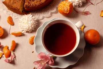 Whole poundcake and slices for an afternoon tea decorated with flowers, fruit, and a tea set. 
