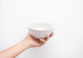 Mano sosteniendo un tazón color blanco en un fondo aislado blanco