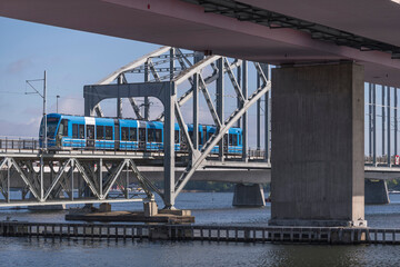 Blue tram on the tram bridge clutch part, line Lidingöbanan between the district Lidingö and end station Ropsten a sunny summer day in Stockholm
