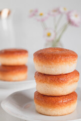 Stack of fresh golden donuts on a white background. Sweet breakfast with round doughnuts.