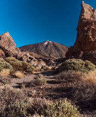 Fototapeta premium Peak of the Mount Teide called 'Pico del Teide' framed by rock formations. Roques de García trail. Volcano and volcanic landscape. Teide National Park, Tenerife, Canary islands, Spain.
