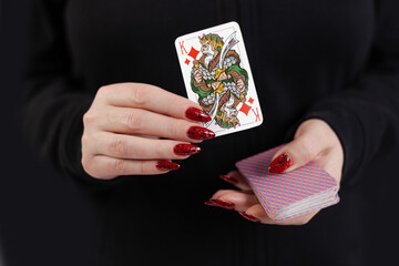 Female hands hold a deck of cards and show tricks.
The photographer is the author of the design of playing cards, which is written in the release of the property. - obrazy, fototapety, plakaty