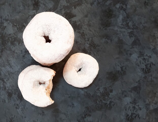 donuts with icing sugar with copy space on dark wooden