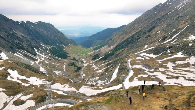 Aerial drone view of nature in Romania. Transfagarasan route in Carpathian mountains, group of tourists taking photos near the view point