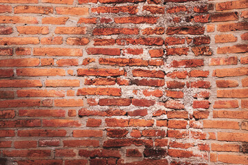 Red brick wall texture. Abstract brick wall background, wall of old, cracked bricks, with a weathered and faded surface.