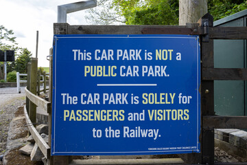 Blue car park is not a public car park, solely for passengers and visitors sign at Bolton Abbey railway station, Yorkshire, UK - obrazy, fototapety, plakaty