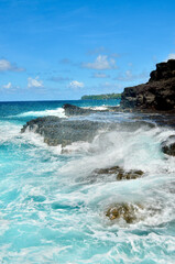 Obraz premium blue ocean waves crashing on rocks
