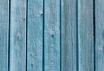 The texture of an old weathered wooden wall with blue paint. Blue wooden background with space to copy.