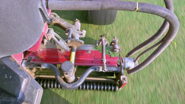 top view video of a lawnmower engine working on the golf course, motor machine job cutting grass golf course, Lawn care staff before the golf tournament, Big mowers works fast.