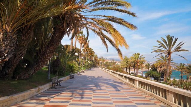 Mediterranean sea coast in Sanremo, Italy. Embankment street with people and a lot of greenery