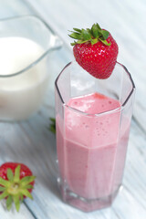 Traditional ayurvedic healthy drink with strawberries of yogurt and ice cube with drinking