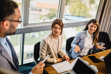 Young Caucasian male coach or speaker make whiteboard presentation for diverse employees in office, focused biracial men trainer present business project on flip chart at meeting