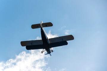 Small biplane flying against the blue sky
