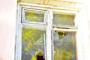 The window in the house is broken glass hooliganism. - obrazy, fototapety, plakaty