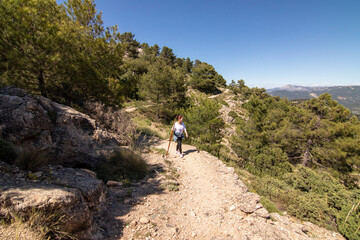 A middle-aged woman hiking the trails of the Sierra De Cazorla, Spain. Nature tourism concept. - obrazy, fototapety, plakaty