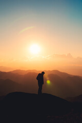 Fototapeta na wymiar Hiker man standing on top of mountain enjoying the beautiful sunset in national park