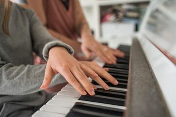 Caucasian mother teaching her child girl to play piano © Yakobchuk Olena