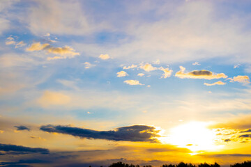 sunset of the yellow sun in a blue sky with rain clouds