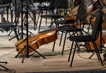The cello lies on the stage next to the classical instruments