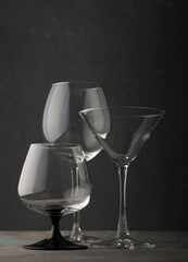 Glass goblets of different shapes for drinks on a dark background. vertical position.