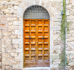 Vintage front door in the medieval city of Italy. Ancient wooden gate. Old city streets, beautiful doors and unusual door handles.