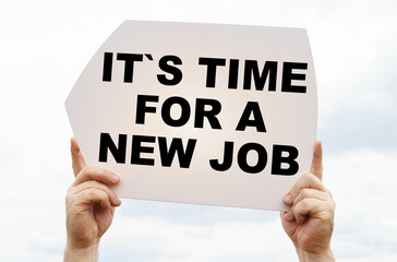 Against the background of the sky in the hands of a man is a sign with the inscription - It is Time For A New Job