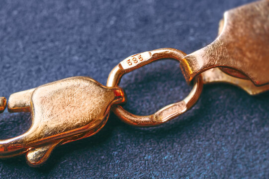 Gold 585 stamp. Gold clasp of a golden bracelet with hallmark 585. It is a type of gold, known as 14K gold. Macro photography. Cropped image.