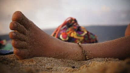 Woman's foot on the sand close-up. Beach with the sea in the background