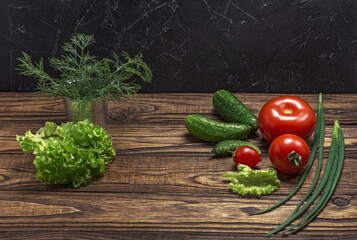 Fresh organic vegetables on a wooden table tomatoes, onions, cucumbers.