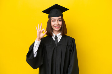 Young university graduate Ukrainian woman isolated on yellow background showing ok sign with fingers