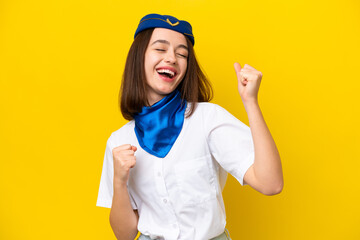Airplane stewardess Ukrainian woman isolated on yellow background celebrating a victory