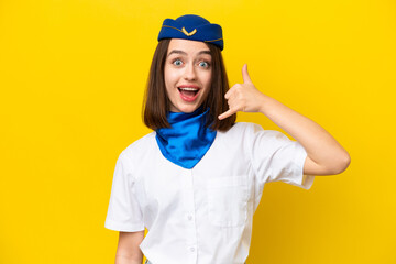 Airplane stewardess Ukrainian woman isolated on yellow background making phone gesture. Call me back sign