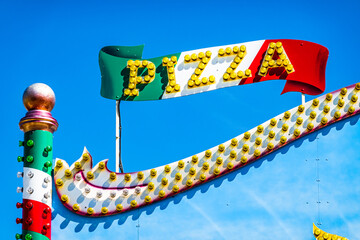 typical pizzeria sign in front of blue sky