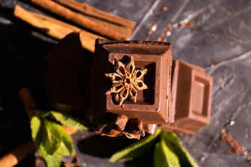 Black chocolate, mint leaf on a dark background