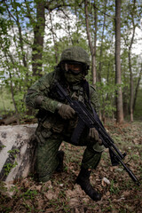 Naklejka premium Military soldier in uniform sitting in the forest, vertical photo