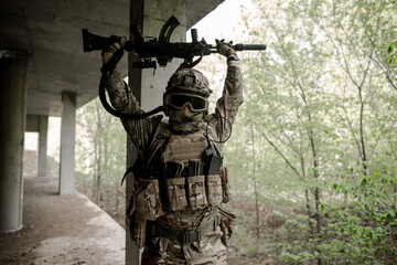 Military soldier in uniform raising his weapon above his head