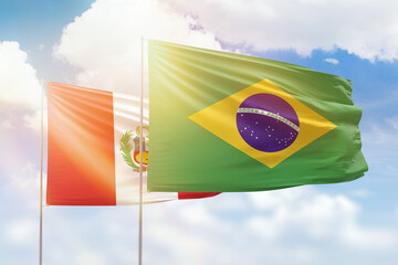 Sunny blue sky and flags of brazil and peru