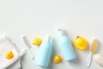 Baby bathing concept. Shower gel and shampoo bottles with yellow ducks and bathroom accessories on...