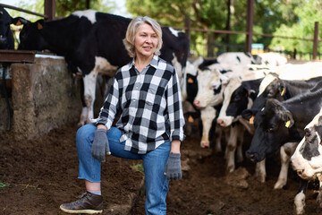 woman owner farmer among herd of cows