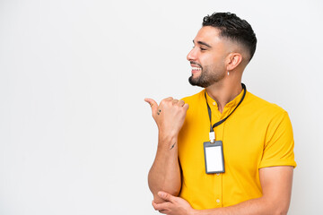 Young Arab man with ID card isolated on white background pointing to the side to present a product