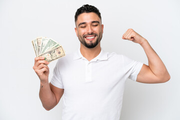 Young Arab man taking a lot of money isolated on white background doing strong gesture