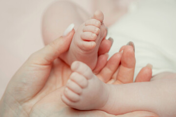 Obraz na płótnie Canvas Baby feet in mother's hands