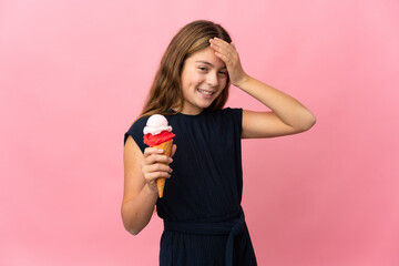 Child with a cornet ice cream over isolated pink background smiling a lot