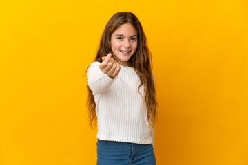 Child over isolated yellow background making money gesture